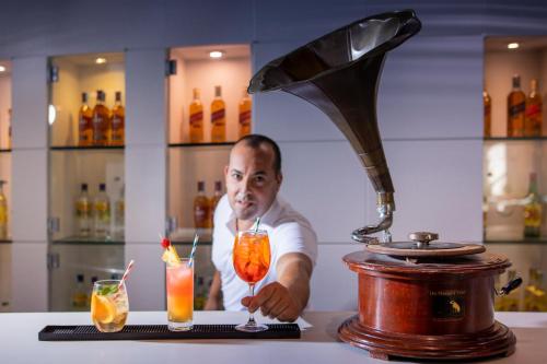 a man behind a counter with two cocktails at Enotel Lido - All Inclusive in Funchal