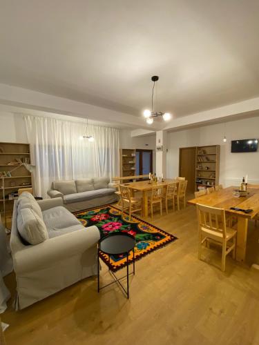 a living room with a white couch and a table at Casuta de la Munte in Sfodea