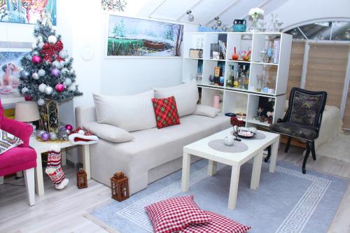 a living room with a white couch and a christmas tree at Art apartman in Kakanj