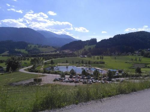 a group of cars parked in a field next to a river at Familienbauernhof Imitz, Ferienwohnung in Spital am Pyhrn