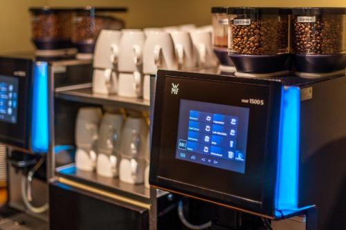 a row of three microwaves on a shelf with spices at Diehls Hotel in Koblenz
