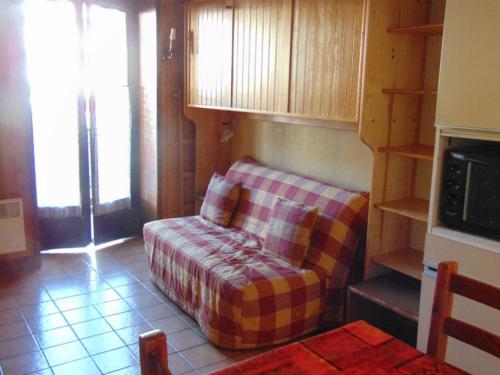 een woonkamer met een bank in een kamer bij Studio Chamonix-Mont-Blanc, 1 pièce, 2 personnes - FR-1-517-23 in Chamonix-Mont-Blanc