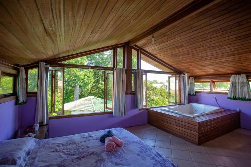 a bedroom with a bed and a bath tub at Caiowa Floripa guesthouse in Florianópolis