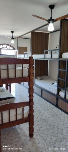 a group of bunk beds in a room at Praia Virgem Hostel in Rio das Ostras