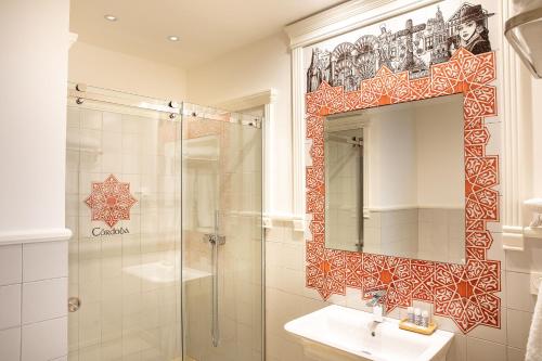 une salle de bain avec une douche, un lavabo et un miroir dans l'établissement Posada Boutique El Gallo Morón, à Morón de la Frontera