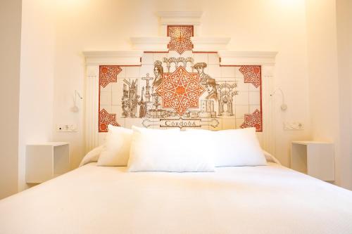 a bedroom with a white bed and a wall at Posada Boutique El Gallo Morón in Morón de la Frontera