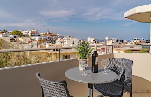 a table with a bottle of wine and glasses on a balcony at Saint Trope Studios in Kalamaki Chanion