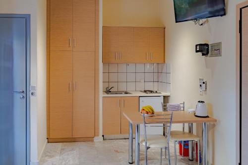 a kitchen with a table and chairs and cabinets at Saint Trope Studios in Kalamaki Chanion