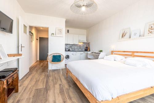 - une chambre blanche avec un grand lit et une cuisine dans l'établissement L'Horizon, à Metz
