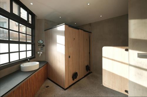 baño con lavabo y puerta de madera en Journey Hostel, en Tainan