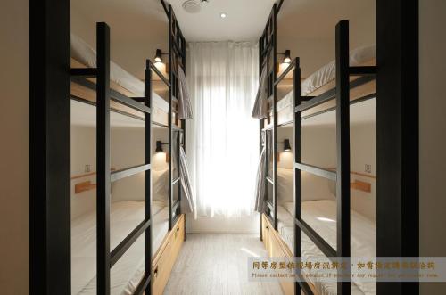 a room with four bunk beds with a window at Journey Hostel in Tainan
