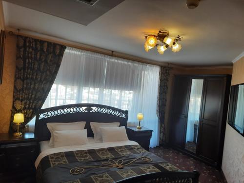 a bedroom with a large bed and a window at Hotel Mir in Rivne