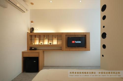 a living room with a tv on a wall at Journey Hostel in Tainan