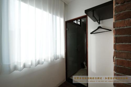 a mirror in a room with a door and a window at Journey Hostel in Tainan