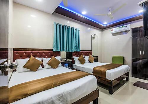 two beds in a hotel room with blue lights at Hotel Plaza- Near Byculla Railway Station in Mumbai