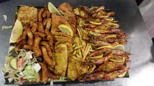 a plate of food with seafood and french fries at Waterside Lodge CC in Piet Retief