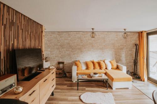 a living room with a couch and a brick wall at Acasă Straja - Casa Vintage in Lupeni
