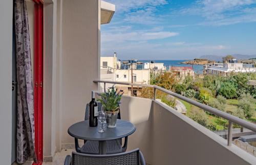 a table on a balcony with a view of the ocean at Saint Trope Studios in Kalamaki Chanion