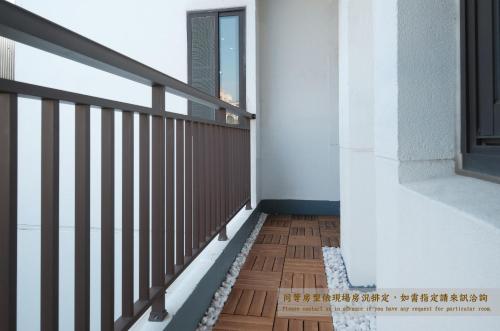 a balcony with a wooden railing and a window at Journey Hostel in Tainan