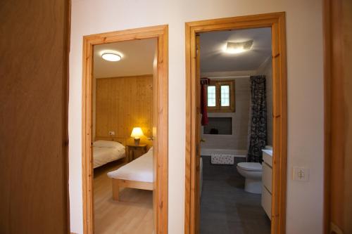 un bagno con vasca e servizi igienici e una camera da letto di La Caseta del bosc de Sort a Sort