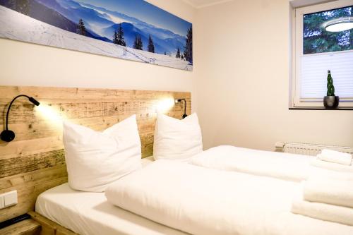 2 Betten in einem Hotelzimmer mit weißen Kissen in der Unterkunft Smart Resorts Haus Saphir Ferienwohnung 505 in Winterberg