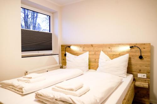 a bedroom with a bed with white sheets and a window at Smart Resorts Haus Saphir Ferienwohnung 508 in Winterberg
