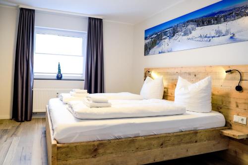 1 dormitorio con 2 camas y ventana grande en Smart Resorts Haus Saphir Ferienwohnung 504, en Winterberg