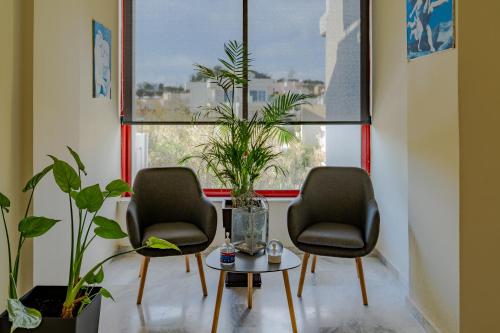 two chairs and a table in front of a window at Saint Trope Studios in Kalamaki Chanion