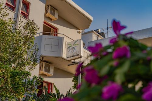 a sign on the side of a building with purple flowers at Saint Trope Studios in Kalamaki Chanion