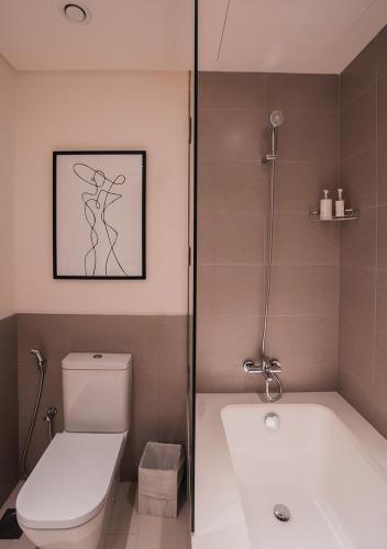 a bathroom with a shower and a toilet and a tub at Nasma Luxury Stays - Elegant Condo With City Views And Dubai Skyline in Dubai