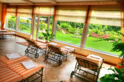 a screened in porch with chairs and a couch at Hotel Rösch in Klagenfurt