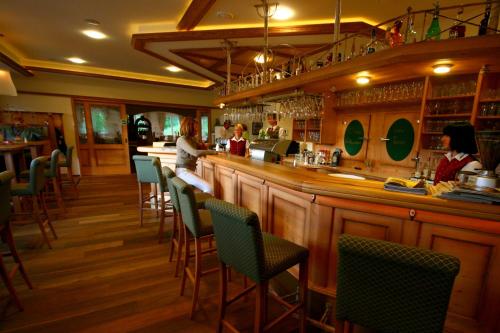a restaurant with a bar with people sitting at it at Hotel Rösch in Klagenfurt