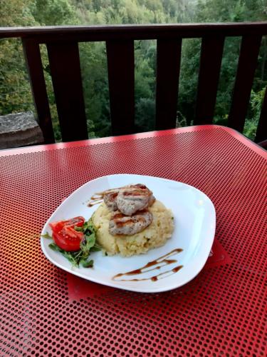 a white plate of food on a red table at Penzion a Restaurace Belveder Romantico, Mini-zoo, Free parking in Jáchymov
