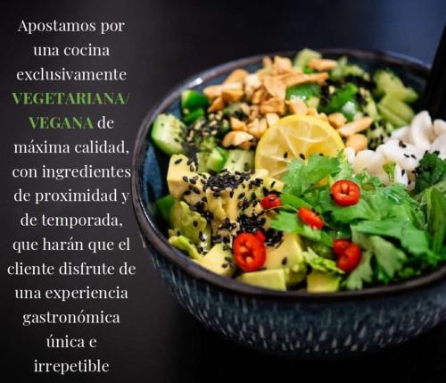 a bowl of food with a salad on a table at Ad Hoc Vitae Retreats & Health Only Adults in Beniarbeig