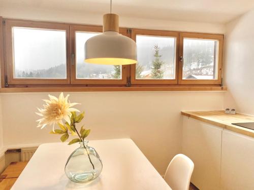 a vase with a flower on a table in a kitchen at Gemütliche Ferienwohnung am Tegernsee - ruhig im Dachgeschoss in Bad Wiessee