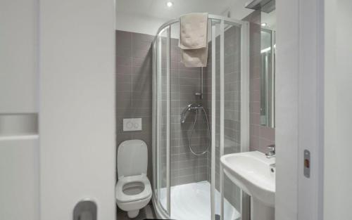 a bathroom with a shower and a toilet and a sink at Apple Inn in Warsaw