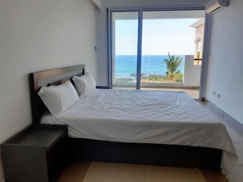 een slaapkamer met een bed en uitzicht op de oceaan bij La Falaise Sea Front Villa in Flic-en-Flac