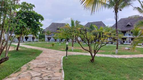a path leading to a resort with palm trees at Karibuni Hotel & Villas in Mambrui