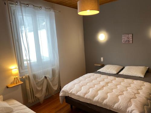 een slaapkamer met een bed en een groot raam bij Crème in Les Chabottes