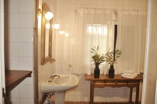 uma casa de banho branca com um lavatório e um espelho em Casa La Veguetilla en San Mateo em Vega de San Mateo