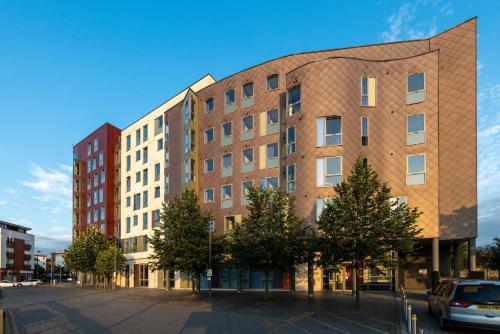 a brick building with trees in front of a street at For Students Only Collegiate Athena Hall Ipswich in Ipswich