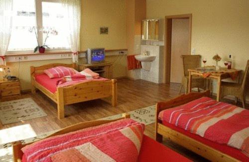a living room with two beds and a kitchen at Econo Motel Goelzer in Büchenbeuren