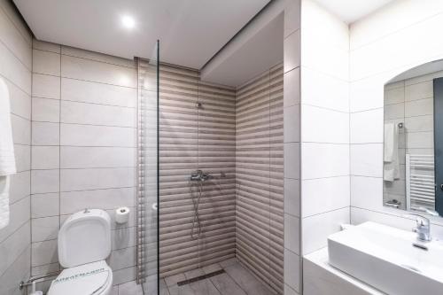 a bathroom with a shower and a toilet and a sink at Lingos Hotel in Florina