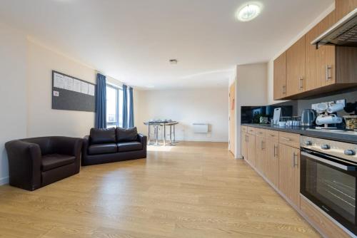 a living room with a couch and a kitchen at For Students Only Collegiate Athena Hall Ipswich in Ipswich