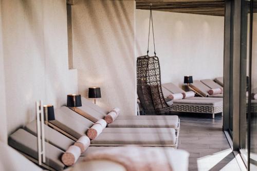 a living room with couches and chairs in a room at Panoramahotel Am Sonnenhang in Tirolo