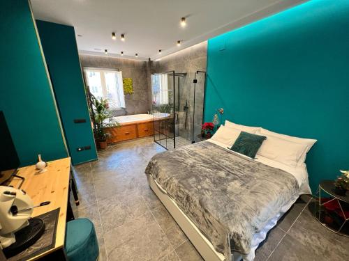 um quarto com uma parede azul, uma cama e uma banheira em ORLANDO relais em Nápoles