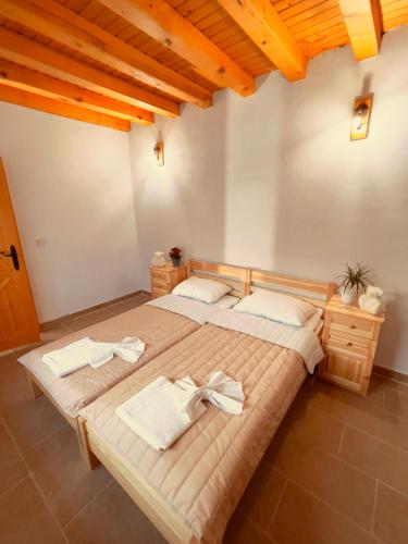 two beds in a room with wooden ceilings at Къща за гости На Мечка in Oborishte