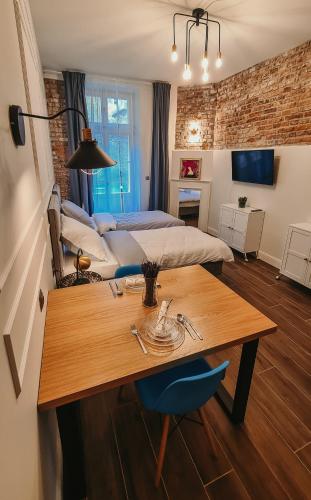 Old Town Suite في كراكوف: غرفة معيشة مع طاولة وسرير وغرفة نوم