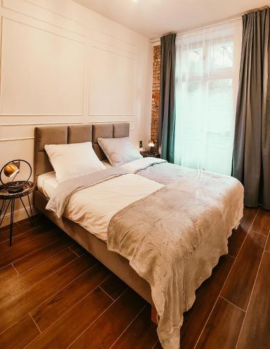 1 cama grande en un dormitorio con ventana en Old Town Suite en Cracovia