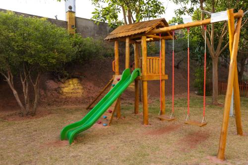 a playground with a green slide in a park at Intercity Vinhedo in Vinhedo